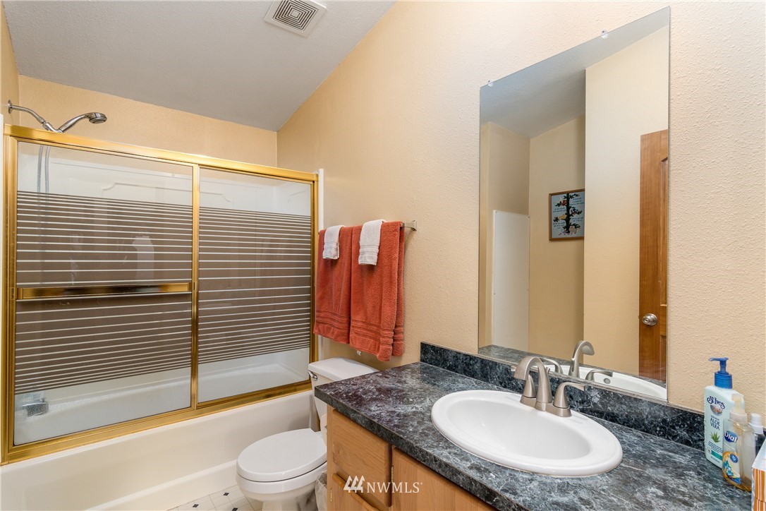 5509 Mt Solo Road Longview, WA 98632 - Photo 14 of 22 a bathroom with a granite countertop sink toilet a mirror and bathtub