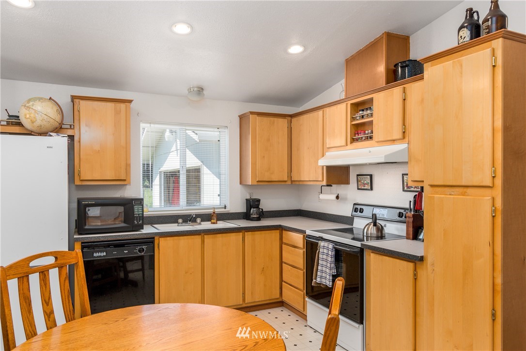 5509 Mt Solo Road Longview, WA 98632 - Photo 6 of 22 a kitchen with stainless steel appliances granite countertop a refrigerator a sink dishwasher a stove and white countertops with wooden floor