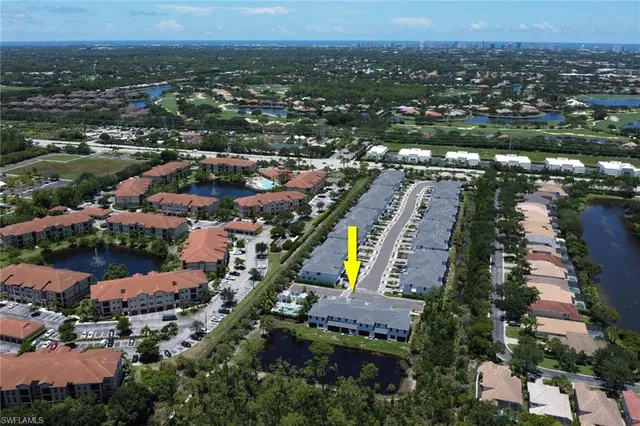 an aerial view of residential houses with outdoor space and lake view