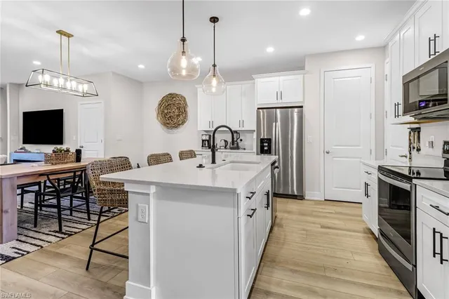 a kitchen with kitchen island granite countertop a sink appliances and cabinets