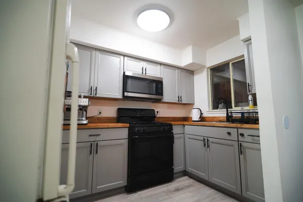 a kitchen with a refrigerator a stove top oven a sink dishwasher and wooden floor