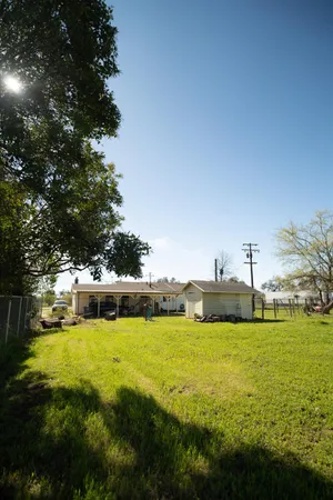 a front view of a house with a yard and large trees