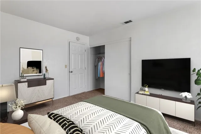 a bedroom with a bed and a flat screen tv