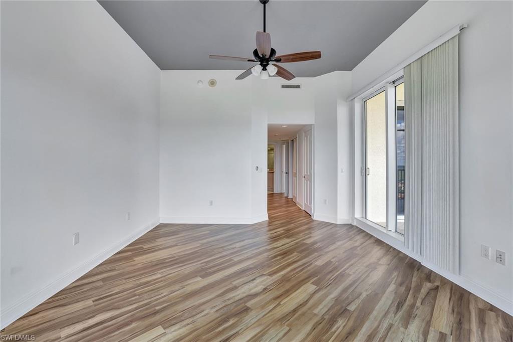 1060 Borghese Lane, Unit 2001 Naples, FL 34114 - Photo 13 of 35 Empty room with light wood-style floors and ceiling fan