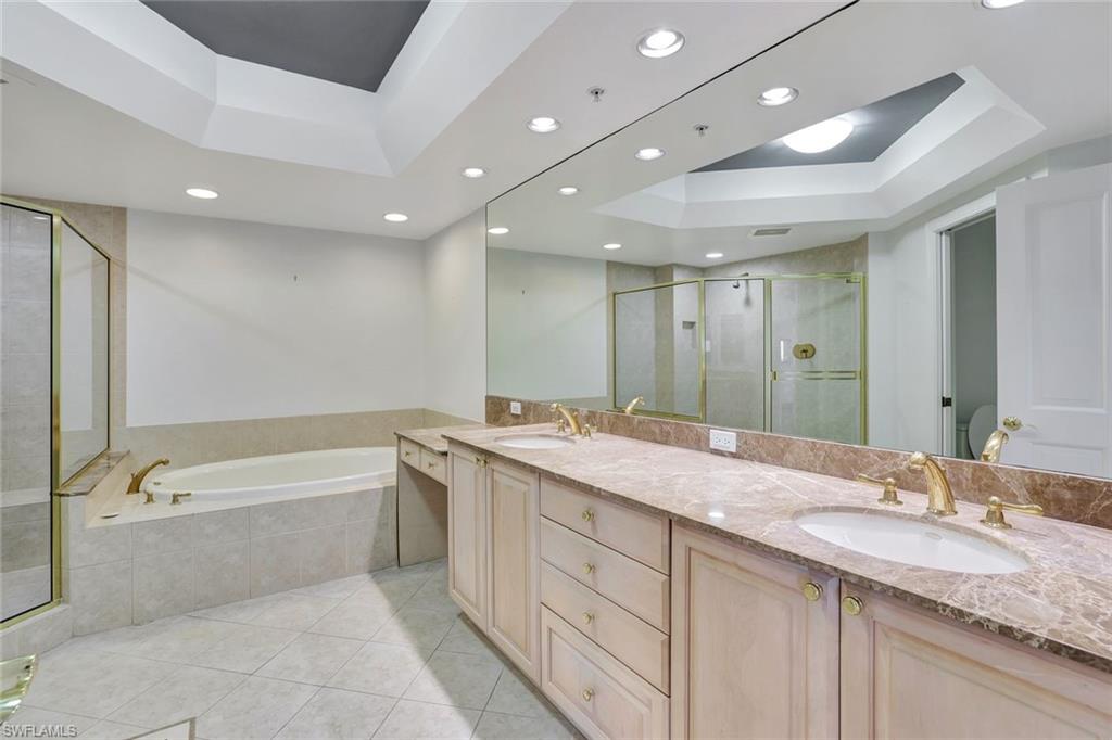 1060 Borghese Lane, Unit 2001 Naples, FL 34114 - Photo 16 of 35 Bathroom with a tray ceiling, a stall shower, a garden tub, double vanity, and light tile patterned floors