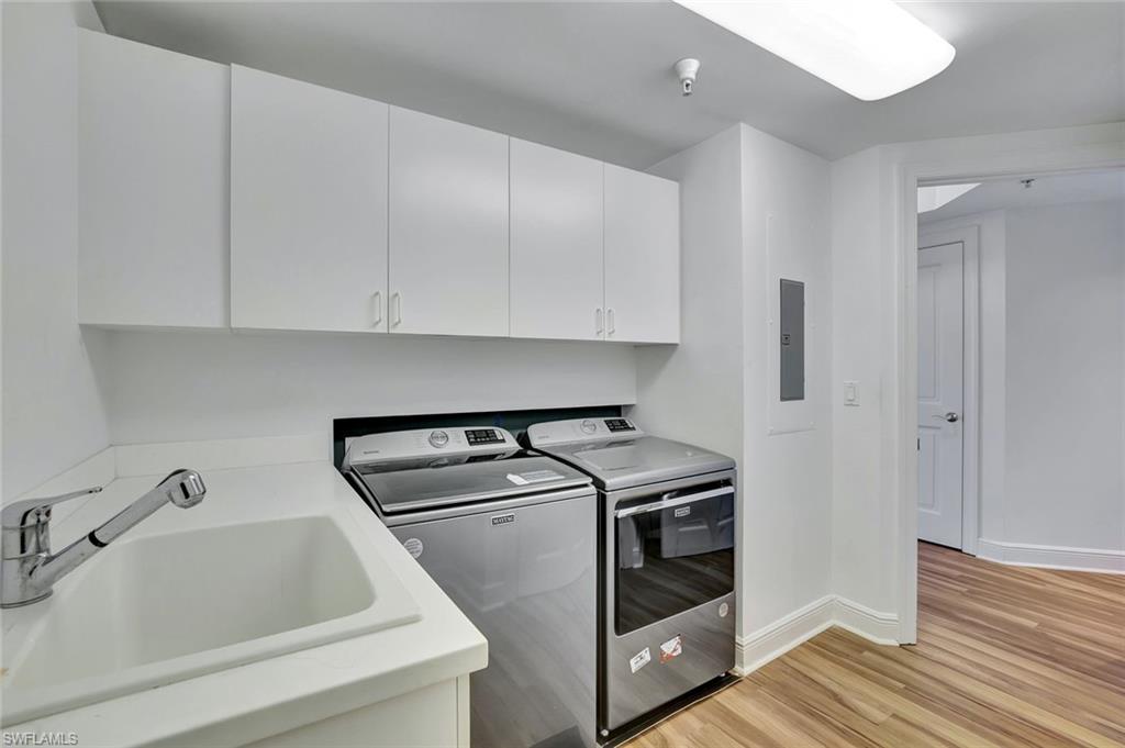 1060 Borghese Lane, Unit 2001 Naples, FL 34114 - Photo 24 of 35 Laundry area featuring light wood-style flooring, washer and clothes dryer, and cabinet space