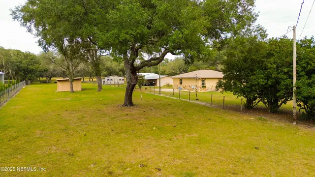 a view of yard with swimming pool and trees