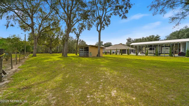 a view of swimming pool with large trees and a big yard