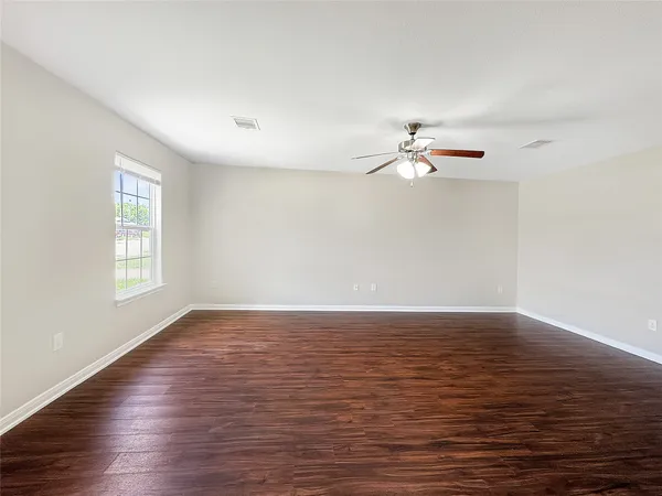 a view of a room with wooden floor and a ceiling fan