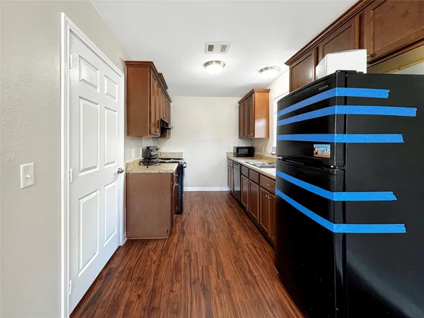 a kitchen with stainless steel appliances a refrigerator and wooden floor