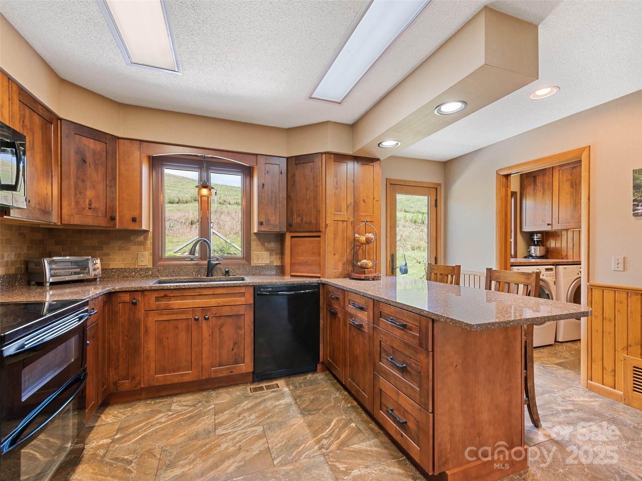 3735 Iron Duff Road Waynesville, NC 28785 - Photo 16 of 48 a large kitchen with stainless steel appliances granite countertop a sink and cabinets