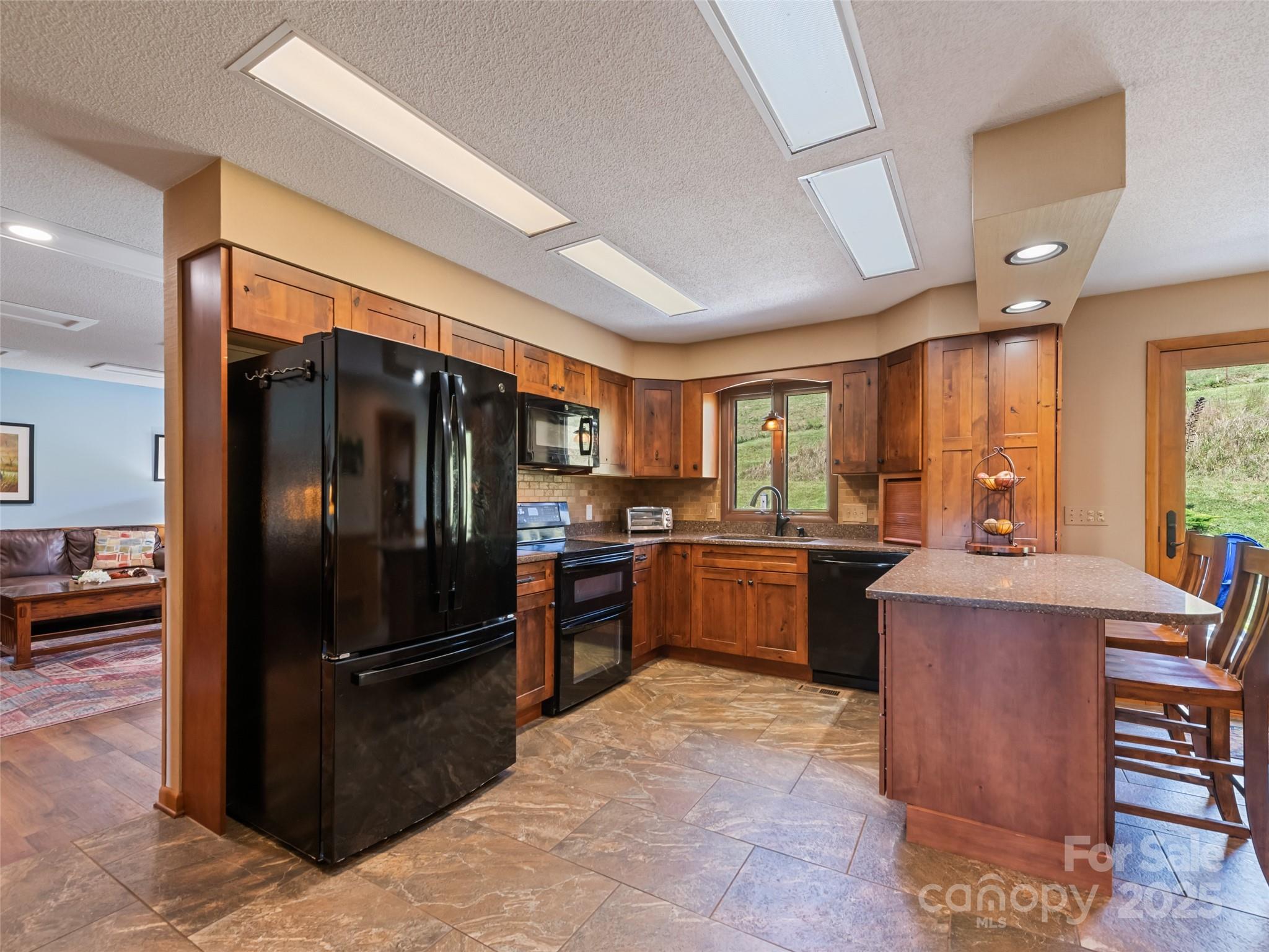 3735 Iron Duff Road Waynesville, NC 28785 - Photo 17 of 48 a kitchen with stainless steel appliances granite countertop a refrigerator stove and sink