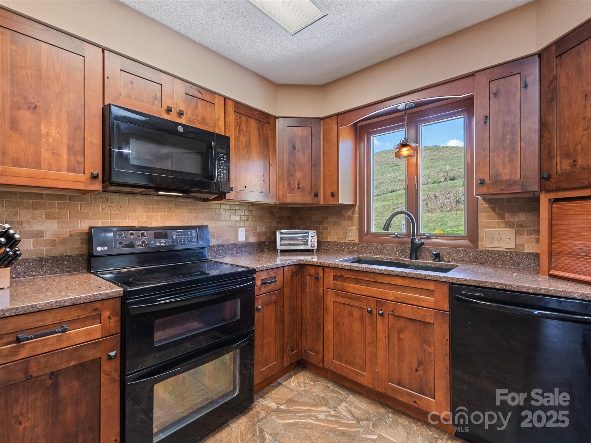 3735 Iron Duff Road Waynesville, NC 28785 - Photo 19 of 48 a kitchen with stainless steel appliances a stove sink microwave and cabinets