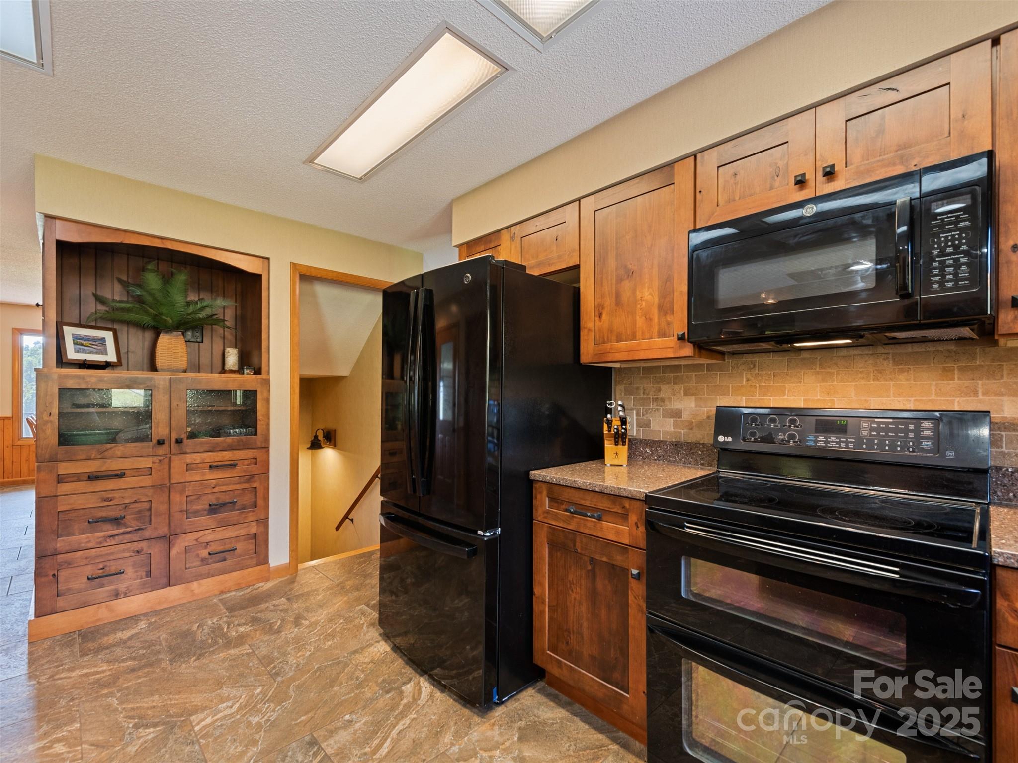 3735 Iron Duff Road Waynesville, NC 28785 - Photo 21 of 48 a kitchen with granite countertop a stove and a refrigerator