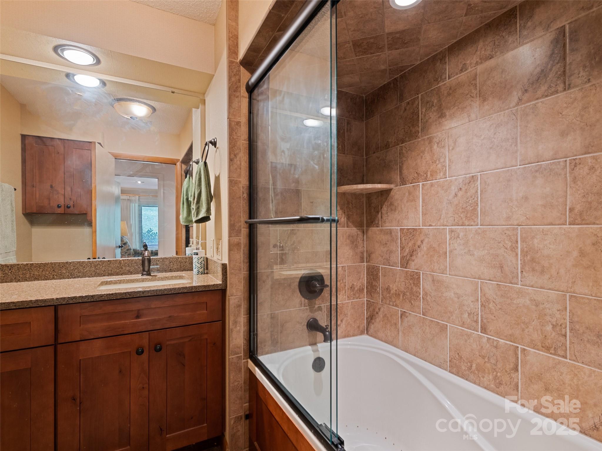 3735 Iron Duff Road Waynesville, NC 28785 - Photo 30 of 48 a bathroom with a tub sink shower and mirror