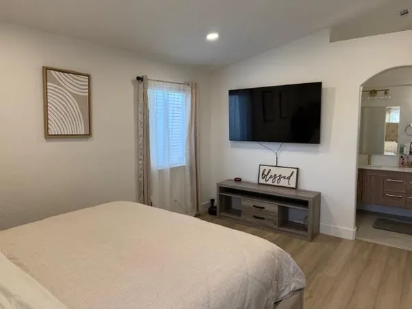 a bedroom with a bed and a flat screen tv