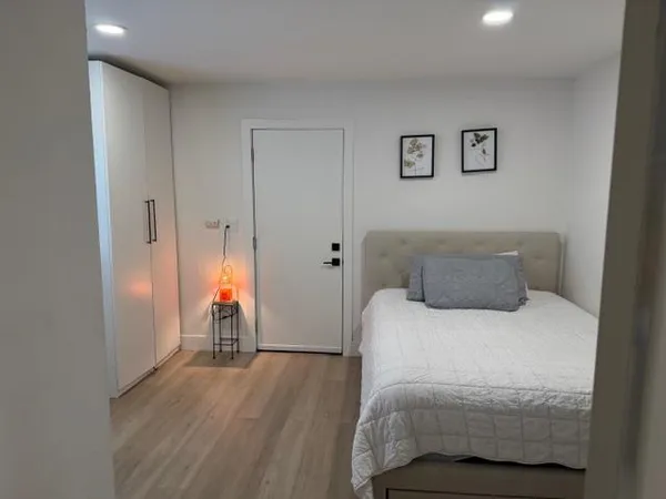 a bedroom with a bed and wooden floor