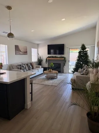 a living room with furniture a flat screen tv and a fireplace