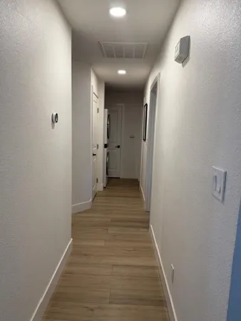 a view of a hallway with wooden floor