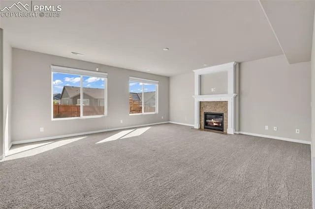 an empty room with windows and fireplace