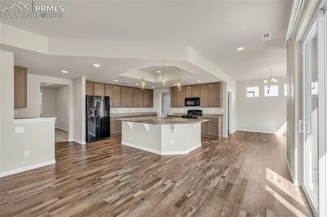 a large kitchen with kitchen island white cabinets and stainless steel appliances