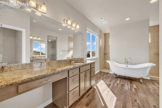 a spacious bathroom with a granite countertop sink a toilet a mirror and bathtub