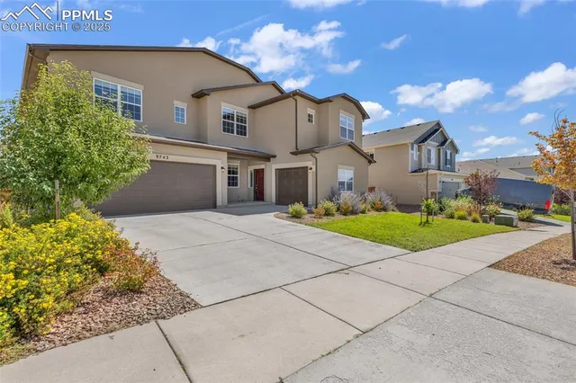 a front view of a house with a garden and yard