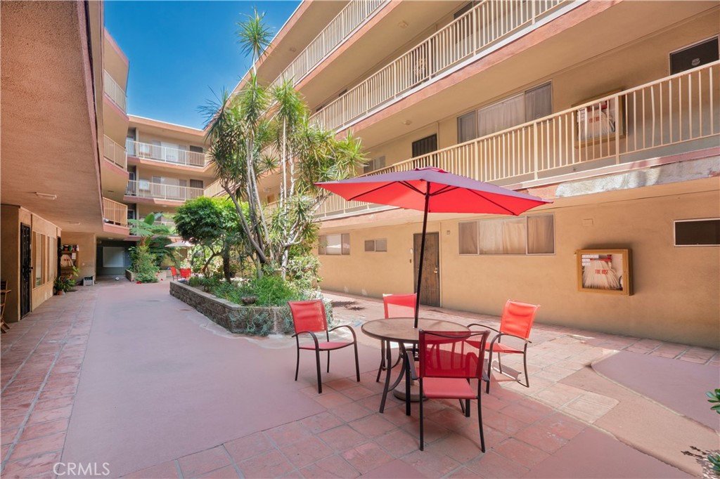 545 Chestnut Avenue, Unit 104 Long Beach, CA 90802 - Photo 17 of 48 a view of a patio with a table and chairs under an umbrella