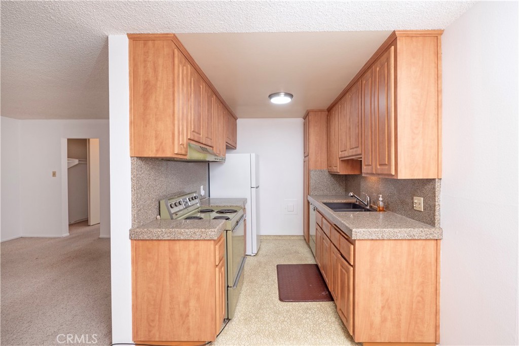545 Chestnut Avenue, Unit 104 Long Beach, CA 90802 - Photo 21 of 48 a kitchen with stainless steel appliances granite countertop a sink stove and refrigerator