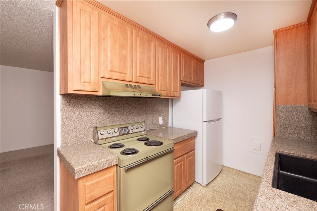 545 Chestnut Avenue, Unit 104 Long Beach, CA 90802 - Photo 25 of 48 a kitchen with stainless steel appliances granite countertop a stove and a refrigerator