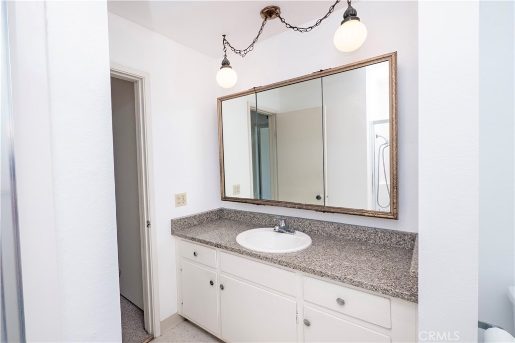 545 Chestnut Avenue, Unit 104 Long Beach, CA 90802 - Photo 32 of 48 a bathroom with a granite countertop sink and a mirror