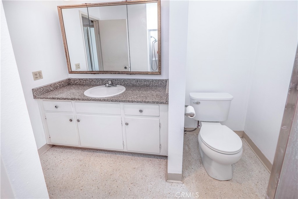 545 Chestnut Avenue, Unit 104 Long Beach, CA 90802 - Photo 33 of 48 a bathroom with a granite countertop toilet and a sink