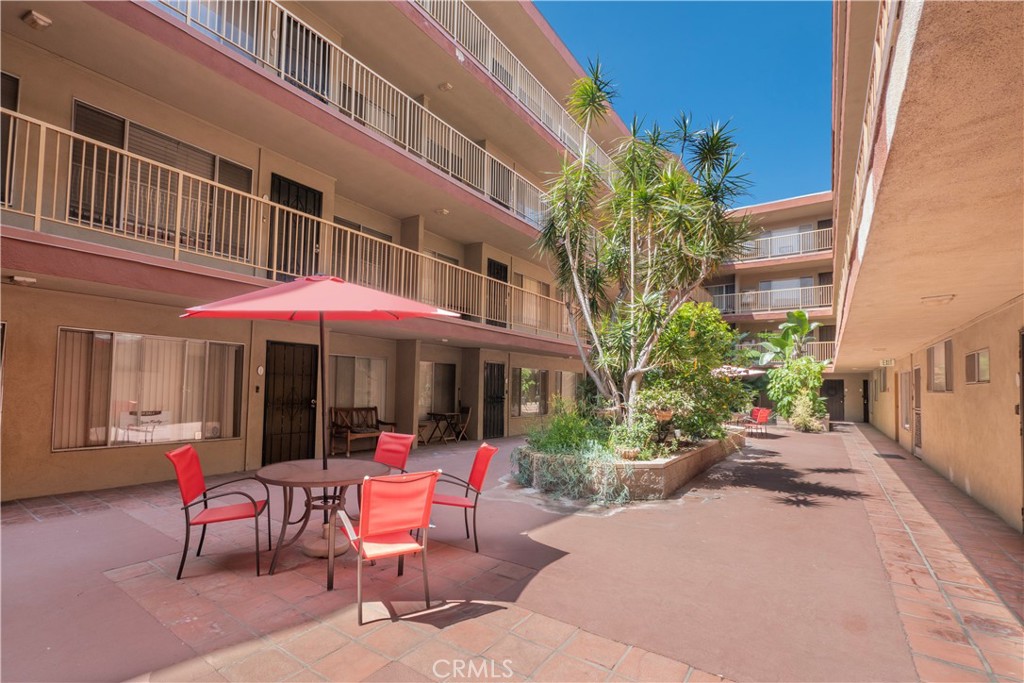 545 Chestnut Avenue, Unit 104 Long Beach, CA 90802 - Photo 6 of 48 a view of a patio with a table and chairs under an umbrella