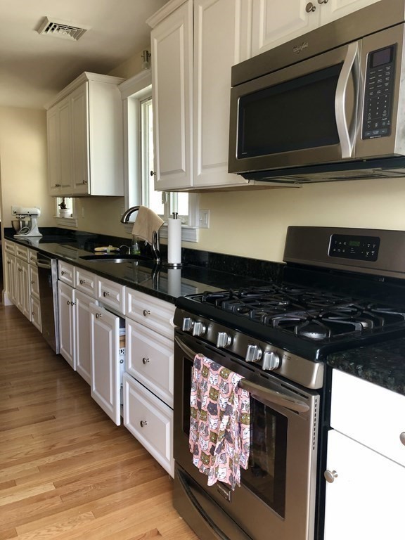 a kitchen with stainless steel appliances granite countertop a stove and a microwave