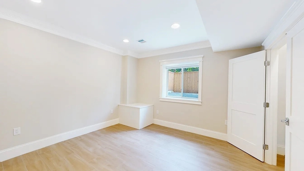 262 Brown Street, Unit 2 Waltham, MA 02453 - Photo 3 of 8 a view of an empty room with wooden floor and a window