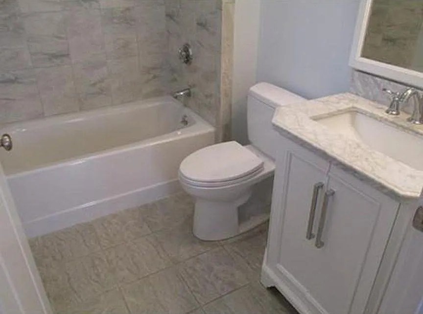 262 Brown Street, Unit 2 Waltham, MA 02453 - Photo 4 of 8 a bathroom with a granite countertop toilet sink and mirror