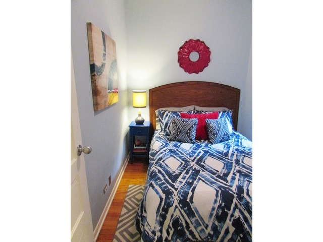902 West Grace Street, Unit 1 Chicago, IL 60613 - Photo 5 of 11 a bedroom with a bed and a painting on the wall