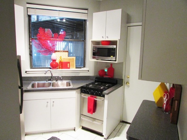 902 West Grace Street, Unit 1 Chicago, IL 60613 - Photo 8 of 11 a kitchen with a sink cabinets and stove top oven