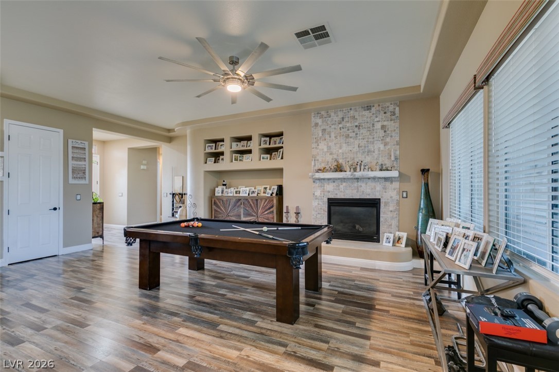 7524 Midnight Rambler Street Las Vegas, NV 89149 - Photo 10 of 51 A refined entertainment space features rich wood flooring and a contemporary tiled fireplace.