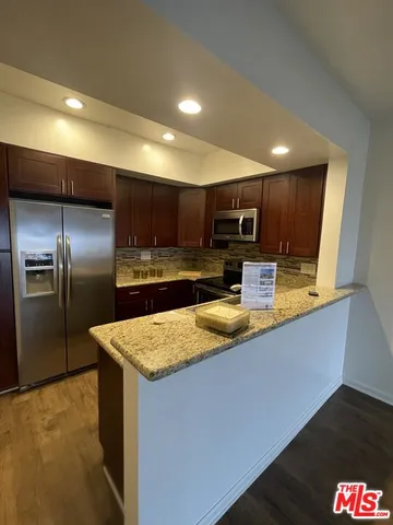 a kitchen with stainless steel appliances granite countertop a sink refrigerator and microwave