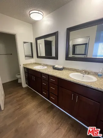 a bathroom with double sink and a mirror