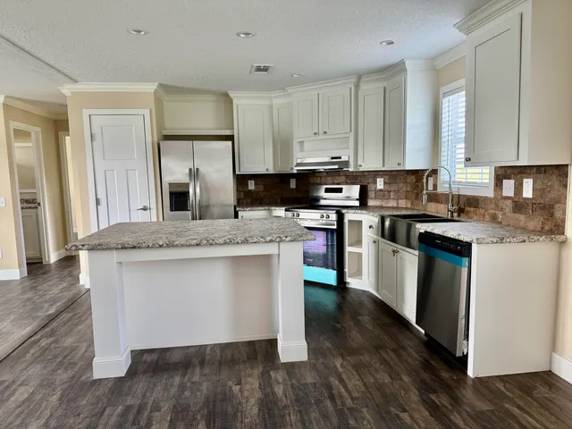 a kitchen with stainless steel appliances granite countertop wooden cabinets and sink