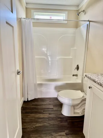 a bathroom with a toilet and a shower