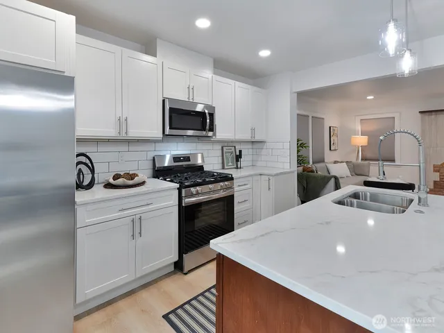a kitchen with stainless steel appliances a sink stove and refrigerator