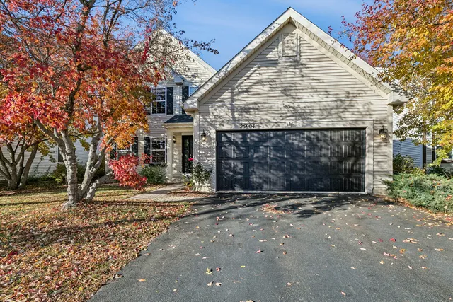 a view of a house with a yard and large tree