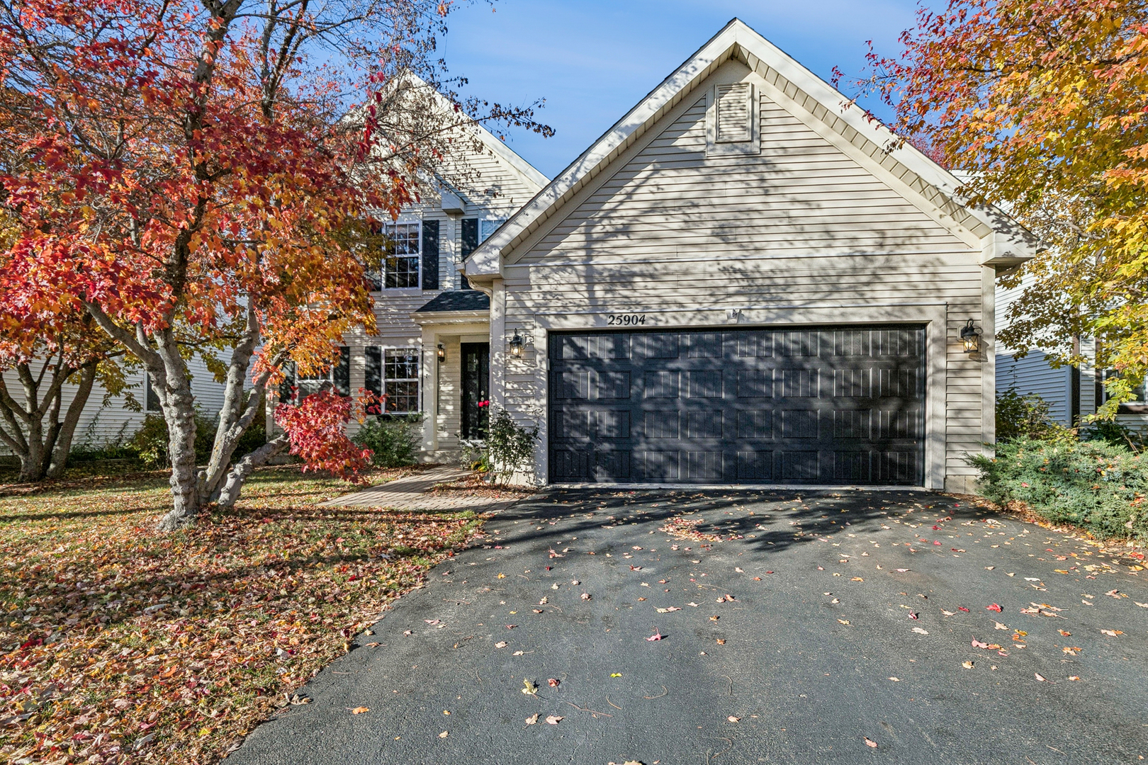 a view of a house with a yard and large tree