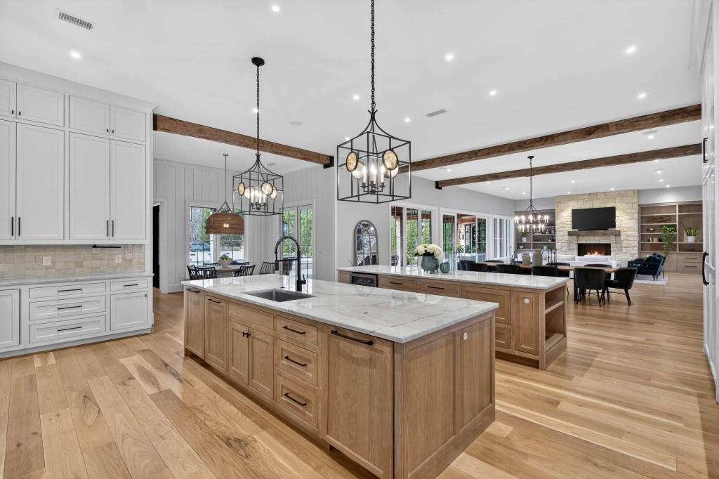 1050 Hamilton Road Northwest Kennesaw, GA 30152 - Photo 19 of 72 a large kitchen with kitchen island a stove a sink a dining table and chairs with wooden floor