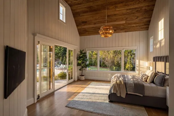 a living room with furniture a large window and a chandelier