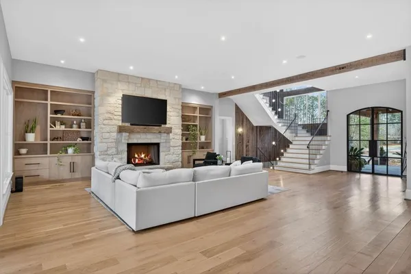 a dining hall with stainless steel appliances kitchen island granite countertop a table chairs and a living room view