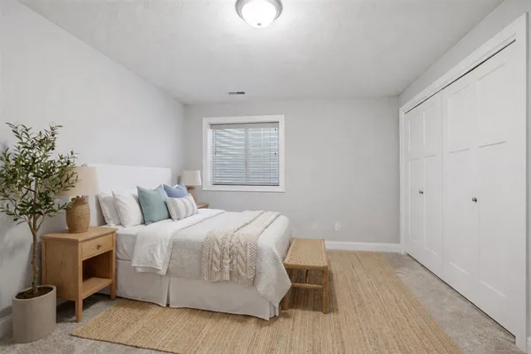 a bedroom with a bed and a potted plant